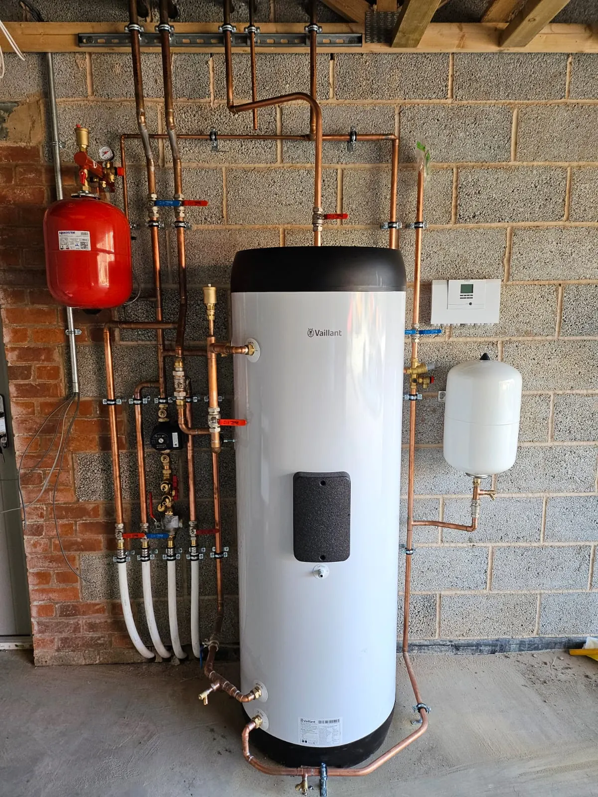 Renewable heating plant room showing cylinders, valves and pipework.