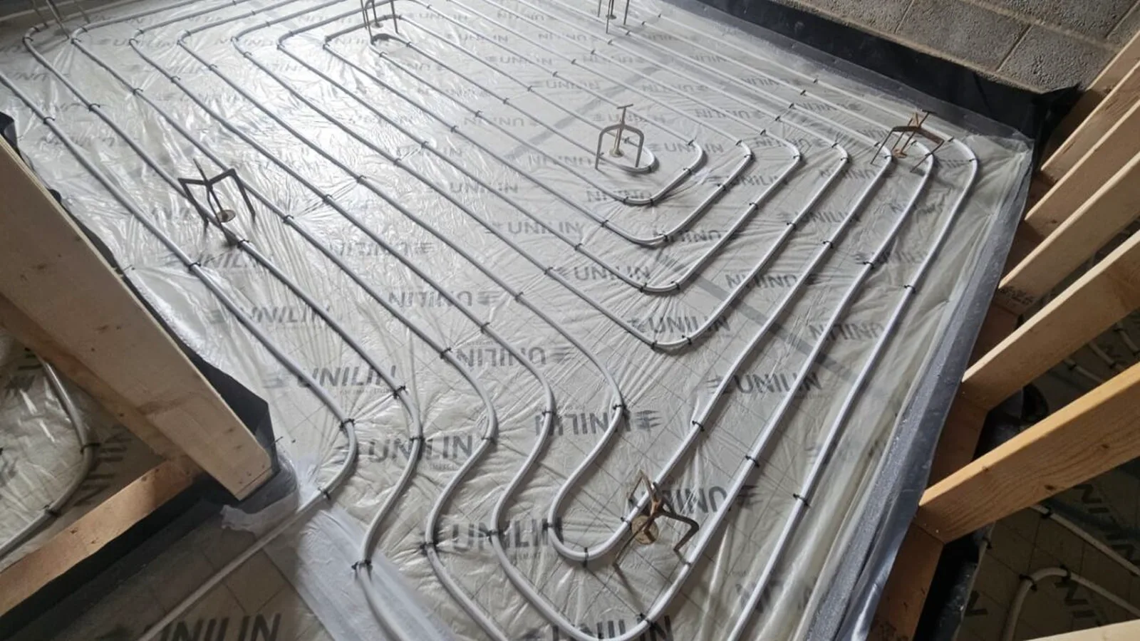 Underfloor heating pipework installed across insulated flooring for a new build.